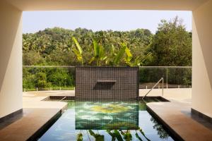 a pool of water with a plant in the middle at Villa Raag in Agonda