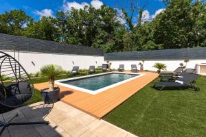 a backyard with a swimming pool and a deck with chairs at Villa Porta Verde I in Balatonalmádi