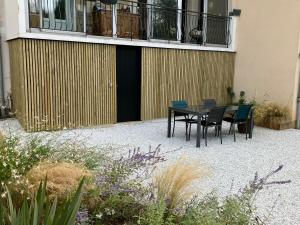 a patio with a table and chairs in front of a building at Chambre indépendante 10min circuit 24h tramway in Le Mans
