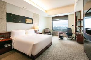 a hotel room with a bed and a desk and a television at InterContinental Foshan by IHG in Foshan
