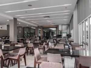 迪沙鲁Amansari Hotel Desaru的有桌椅和窗户的餐厅
