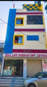 乌贾因Hotel Priyan-Shi Palace AC OR NON AC ROOM Outstanding Property In Ujjain的一座多彩的建筑,前面有一辆汽车