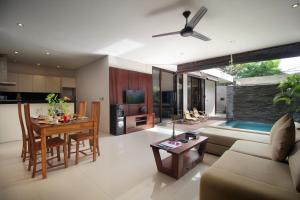 a living room with a couch and a table at Sudha Villa Bali Baik-Baik in Seminyak