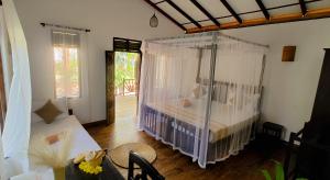 una camera da letto con un letto con zanzariera di Ginger Harmony Guesthouse and Cafe a Tangalle