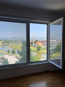 a room with three windows with a view of a river at Ilidža Tower Sapphire Suites in Sarajevo