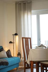 a dining room with a table and a blue couch at The new "Bilocale vista mare" 2025 in Fano