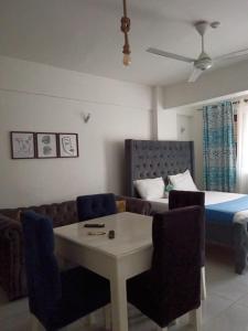 Una sala de estar con una cama, una mesa y sillas. en 5 Minutes to the Beach - Studio, en Mombasa