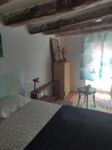 a bedroom with a bed and a table in a room at Sidharta Room in Villalba dels Arcs