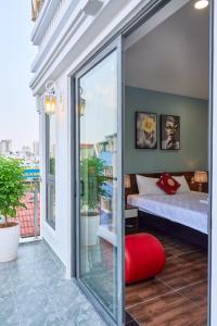 a balcony with a bed and a red stool at Nguyên Hương Hotel in Ho Chi Minh City