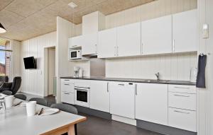 Una cocina con gabinetes blancos y una mesa. en 4 Bedroom Beautiful Home In Ringkøbing, en Ringkøbing