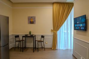 a dining room with a table and chairs and a window at Luxury Acclavio Apartments in Taranto