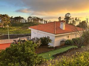 une maison blanche avec un toit orange dans une cour dans l'établissement Casa Rural Margarita, relax, vistas, jardín, à Las Indias