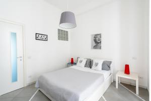 ヴィーコ・エクエンセにあるMarisabella luxury homeの白いベッドルーム(白いベッド1台、赤い椅子付)