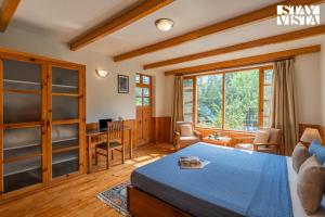 une chambre avec un lit et un bureau dans une pièce dans l'établissement StayVista at Himalayan Retreat Luxury 9BR, 6BR 5BR, 3BR 1BR Villa in Manali, à Manali
