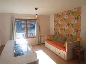 ein Wohnzimmer mit Sofa und Tisch in der Unterkunft Le fleuri ensoleillé de Guzet in Ustou + 16 Fotos