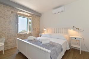 a white bedroom with a bed and a window at Villa Ante in Zaostrog +9 photos