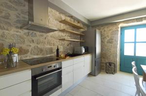 a kitchen with white cabinets and a refrigerator at Villa Ante in Zaostrog