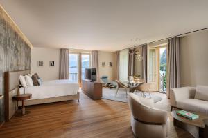 a bedroom with a bed and a living room at Grand Hotel Victoria concept & spa, by R Collection Hotels in Menaggio