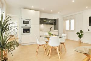 a kitchen with white cabinets and a table and chairs at Del Valle Hogar Centro in Córdoba
