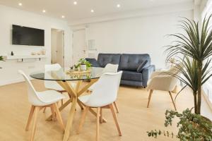 a dining room with a glass table and white chairs at Del Valle Hogar Centro in Córdoba
