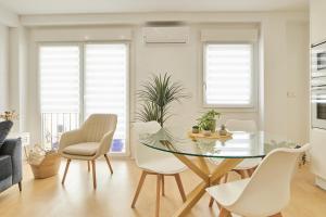 a dining room with a glass table and white chairs at Del Valle Hogar Centro in Córdoba
