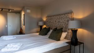 a bedroom with a large white bed with green pillows at Strandvillan Ljunghusen in Ljunghusen +37 photos