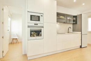 a white kitchen with white cabinets and a sink at Del Valle Hogar Centro in Córdoba +53 photos