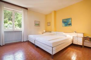 two beds in a bedroom with yellow walls at Casa Rolf-Grande appartamento con vista lago in Pai