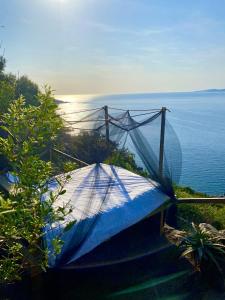 a blue tent sitting on the side of the ocean at Fianca l'Osso in Belvédère