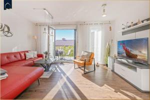 a living room with a red couch and a table at Ferienhaus Nordwind in Kolpinsee