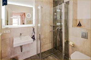 a bathroom with a sink and a shower at Ferienhaus Nordwind in Kolpinsee +26 photos