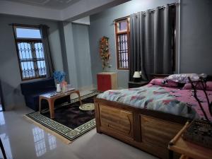 a bedroom with a bed and a table and windows at Karma homestay in Ravangla +49 photos