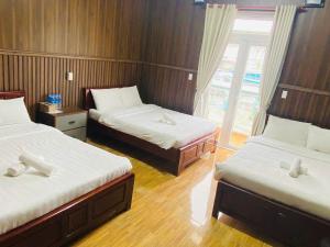 Postel nebo postele na pokoji v ubytování Khách sạn Đoàn Vượng Đà Lạt