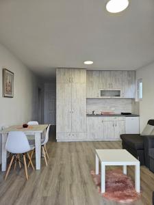 a living room with a table and a kitchen at Open Sky Montenegro in Utjeha