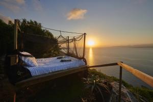 a bed on a hill with the sunset in the background at Fianca l'Osso in Belvédère