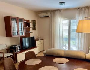 een woonkamer met een bank en een televisie bij Pelješka OREBIĆ in Orebić