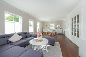 a living room with a blue couch and a table at Ferienhaus Witt in Neue Tiefe Fehmarn
