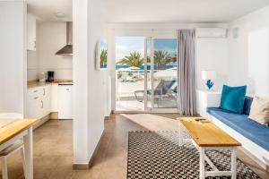 a kitchen and living room with a couch and a table at Neptuno Suites - Adults Only in Costa Teguise