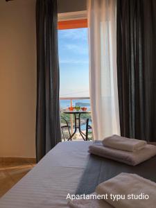 a bedroom with a bed and a view of the ocean at Open Sky Montenegro in Utjeha