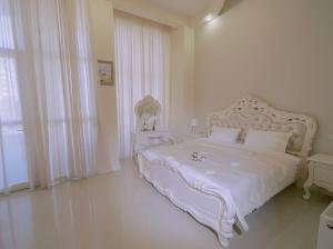 a white bedroom with a large white bed with white sheets at River S hotel in Zugdidi +45 photos