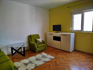a living room with a couch and a table and a chair at Novomesto in Igalo