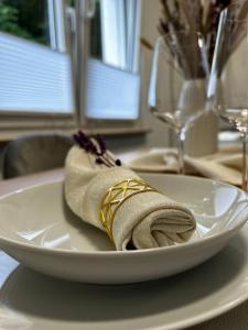 a white plate with a napkin on top of it at Ferienwohnung Elya, Ihre Auszeit zwischen Therme, Outlet, Natur in Bad Münstereifel
