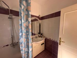 a bathroom with a sink and a shower curtain at Calma rooms in Përmet