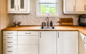 una cucina con mobili bianchi e un lavandino di 3 Bedroom Amazing Home In Elnesvågen a Sylte