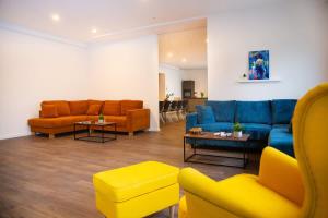 a living room with a blue couch and orange chairs at Belmonte Whirlpool-Sauna-Billard-Kicker-Kino in Bendorf