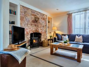 een woonkamer met een blauwe bank en een open haard bij Finest Retreats - Blue Monkey in Cawsand
