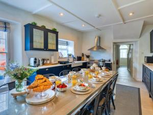 een keuken met een lange tafel met eten erop bij Finest Retreats - Blue Monkey in Cawsand