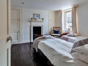 een slaapkamer met 2 bedden en een open haard bij Finest Retreats - Blue Monkey in Cawsand