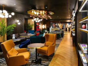 a lobby with chairs and tables in a store at Mercure Lyon Centre Saxe Lafayette in Lyon