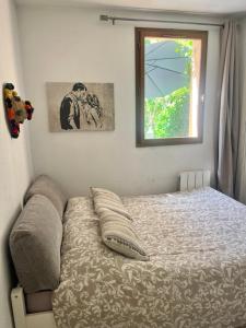 ein kleines Schlafzimmer mit einem Bett und einem Fenster in der Unterkunft Le Nid d'amour Saint Cyr in Les Lecques